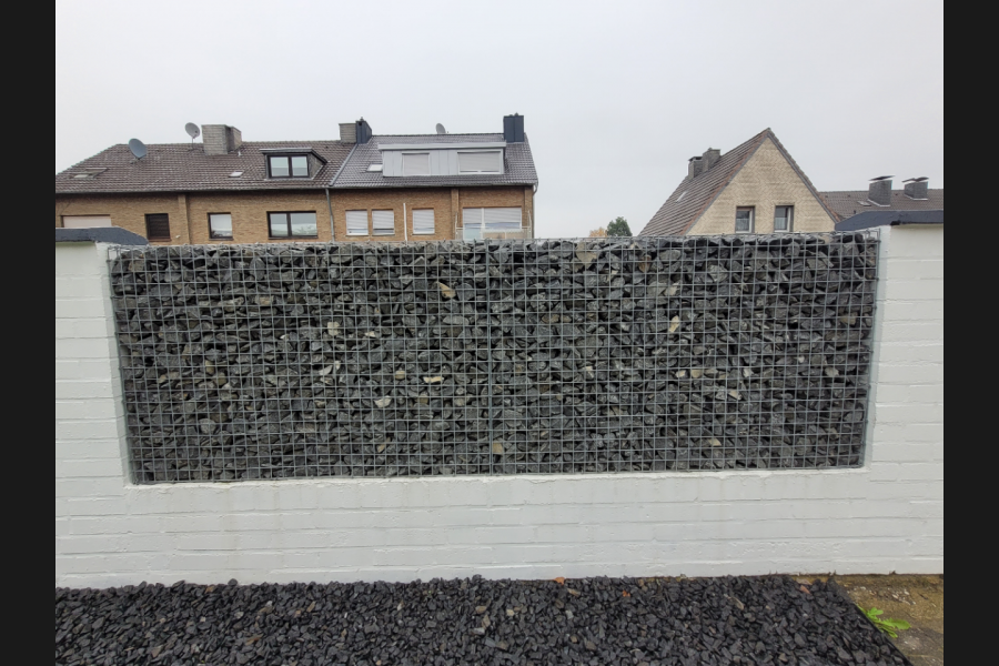 Steinkörbe im bestehenden Zaun Steinkörbe im bestehenden Zaun