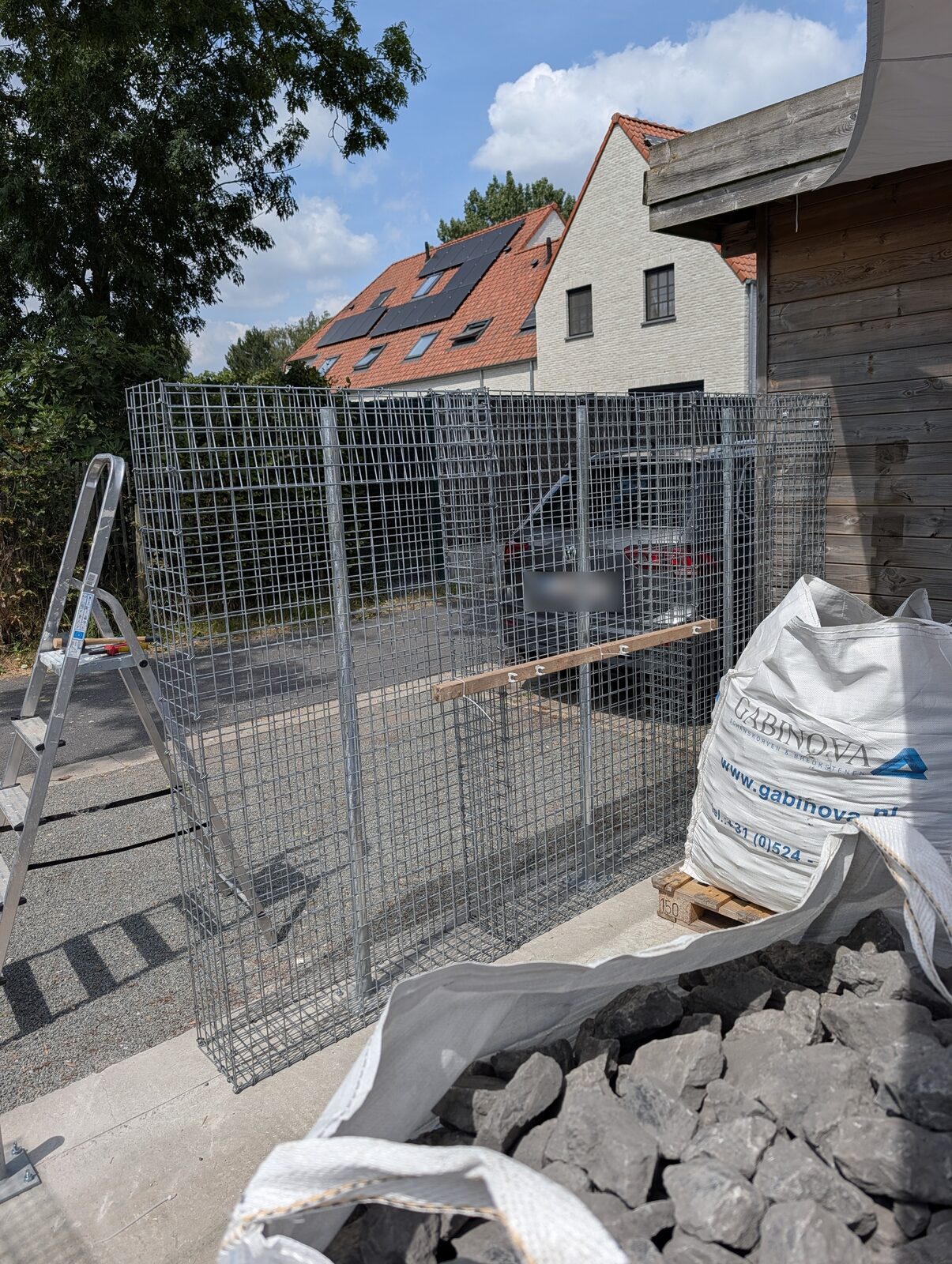Leere Gittermatten vor dem Befüllen, daneben ein Big Bag Ardenner Grau