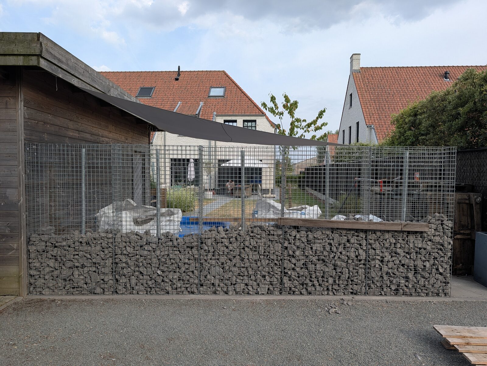 Halb befüllte Gabionenwand, die Gittermatten darüber noch leer
